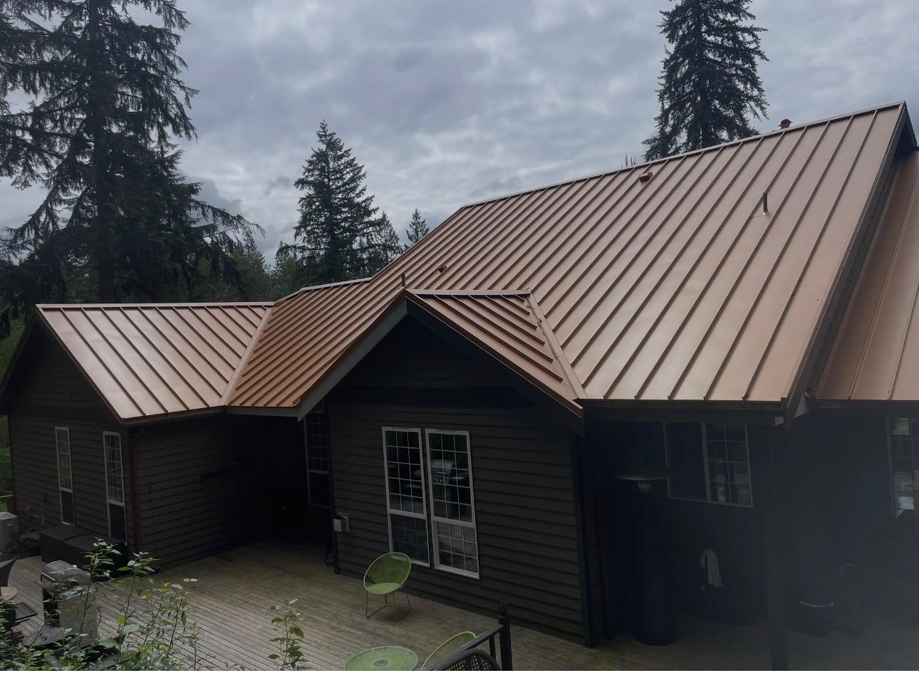 Copper-finish standing seam metal roof over the rear elevation and deck of a home in the Greater Eastside, WA