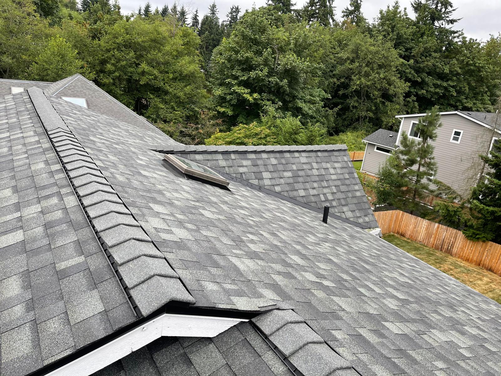 Architectural shingle roof with hip ridges and a skylight on a home in the Greater Eastside, WA