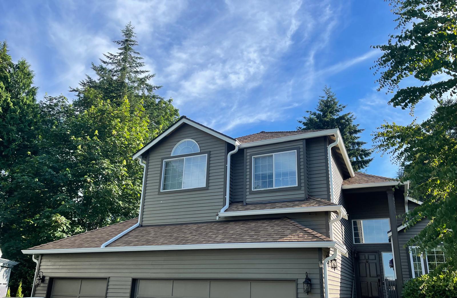 Two-storey home with a completed shingle roof and new white seamless gutters in the Greater Eastside, WA
