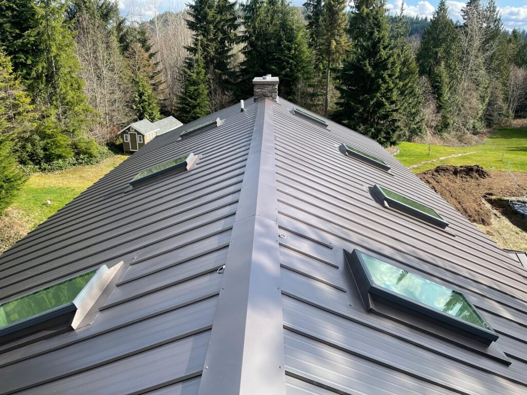 Dark bronze standing seam metal roof with flashed skylights on a home in the Greater Eastside, WA