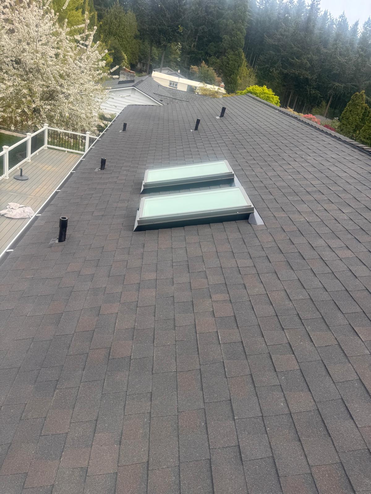 Composition shingle roof with two flashed skylights and new vents on a home in the Greater Eastside, WA