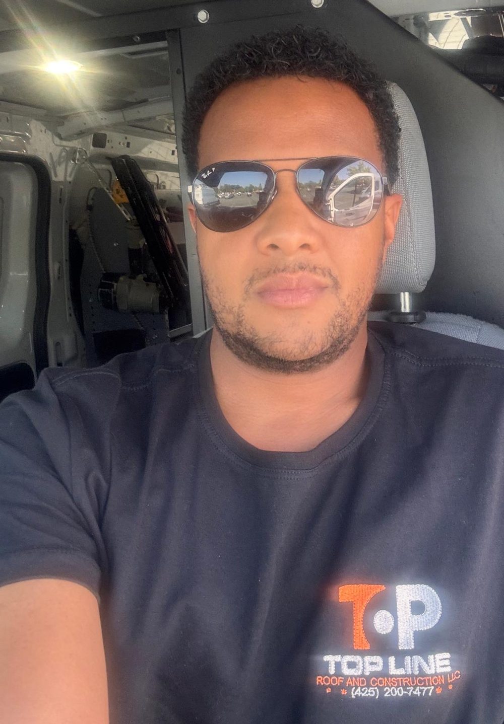 Sam Da Silva, owner of Top Line Roof & Construction, in the company van on the Greater Eastside